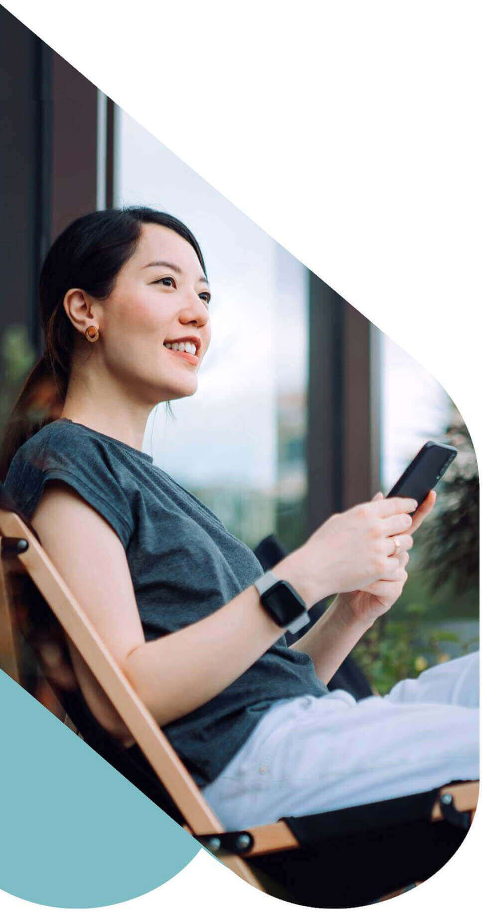 Smiling woman sitting in a chair using her cell phone