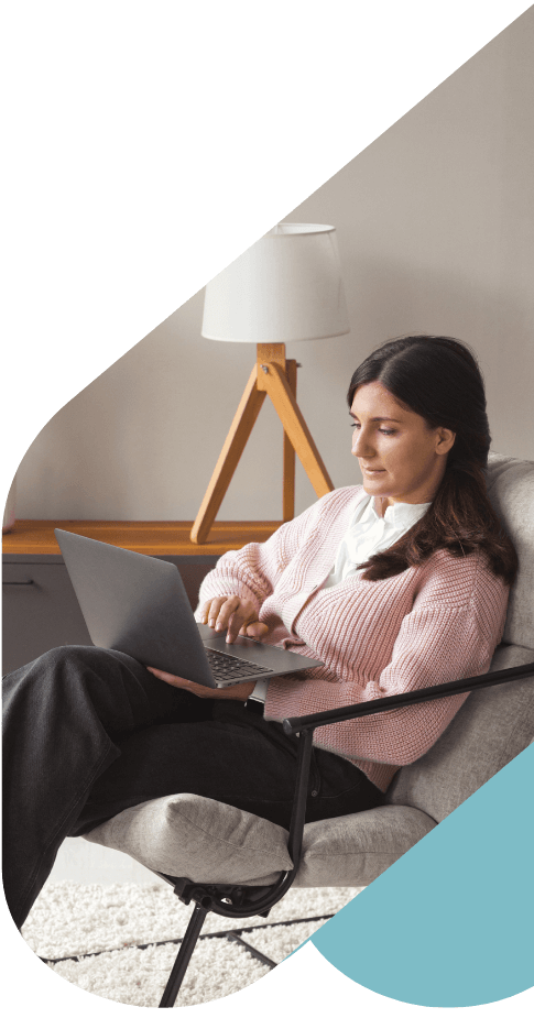 Woman sitting in a chair using a laptop on her lap